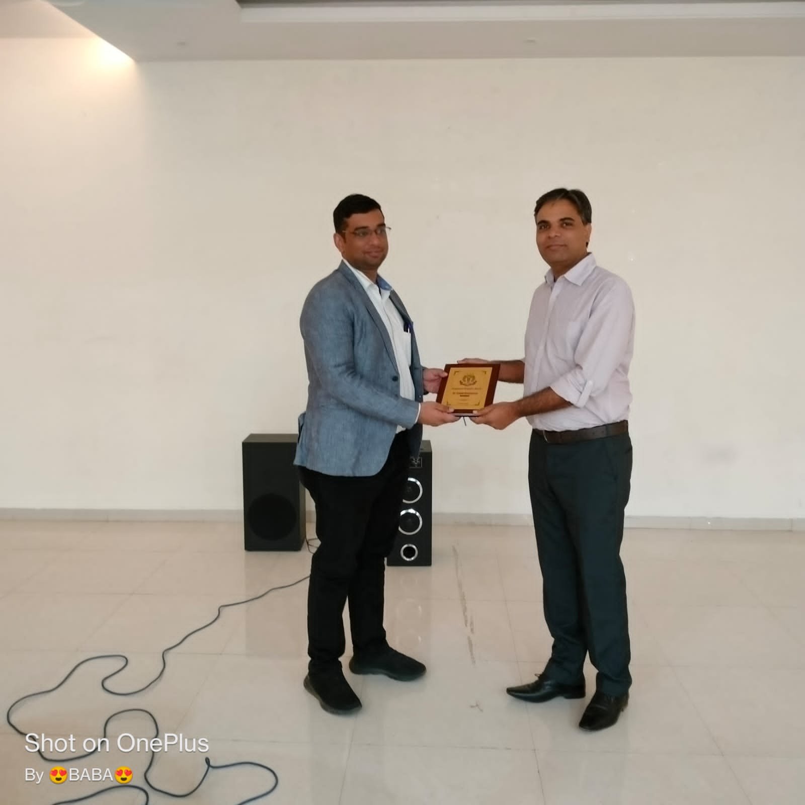 Dr. Sumit Bhatnagar receiving a plaque award